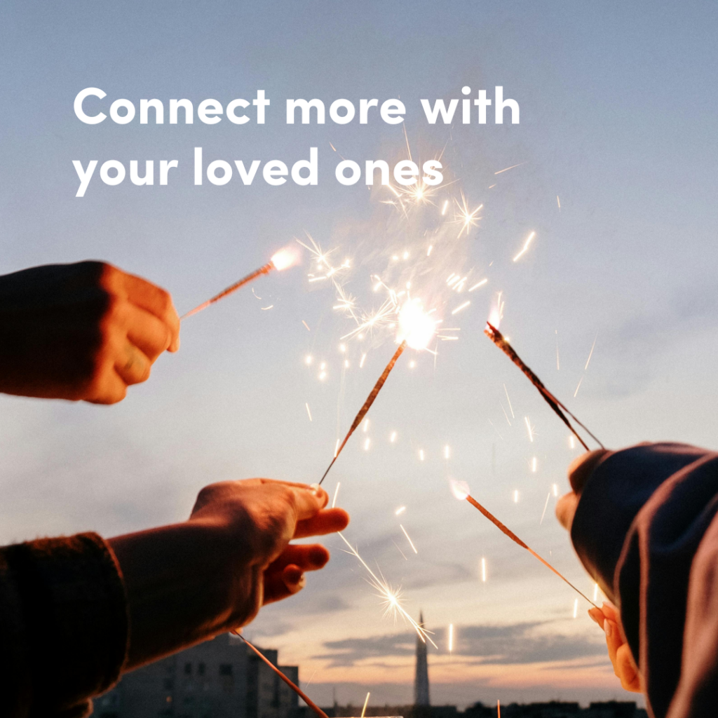 The text 'Connect more with your loved ones' against an image of people's hands holding up a sparkler against a blue skyline.